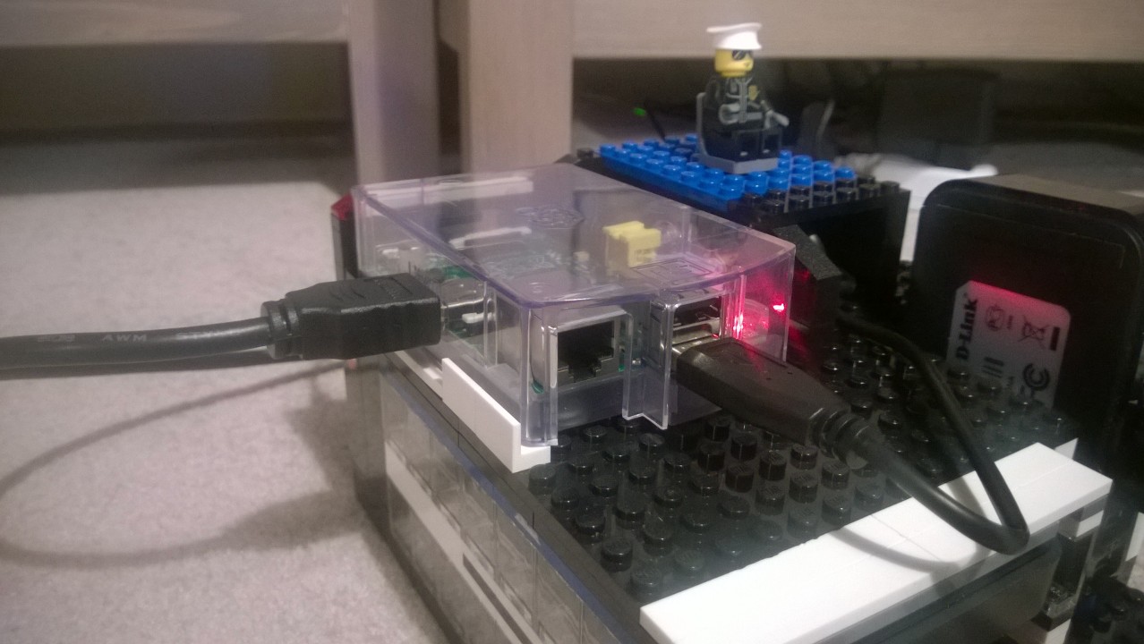 Raspberry Pi in plastic case on top of Lego NAS enclosure