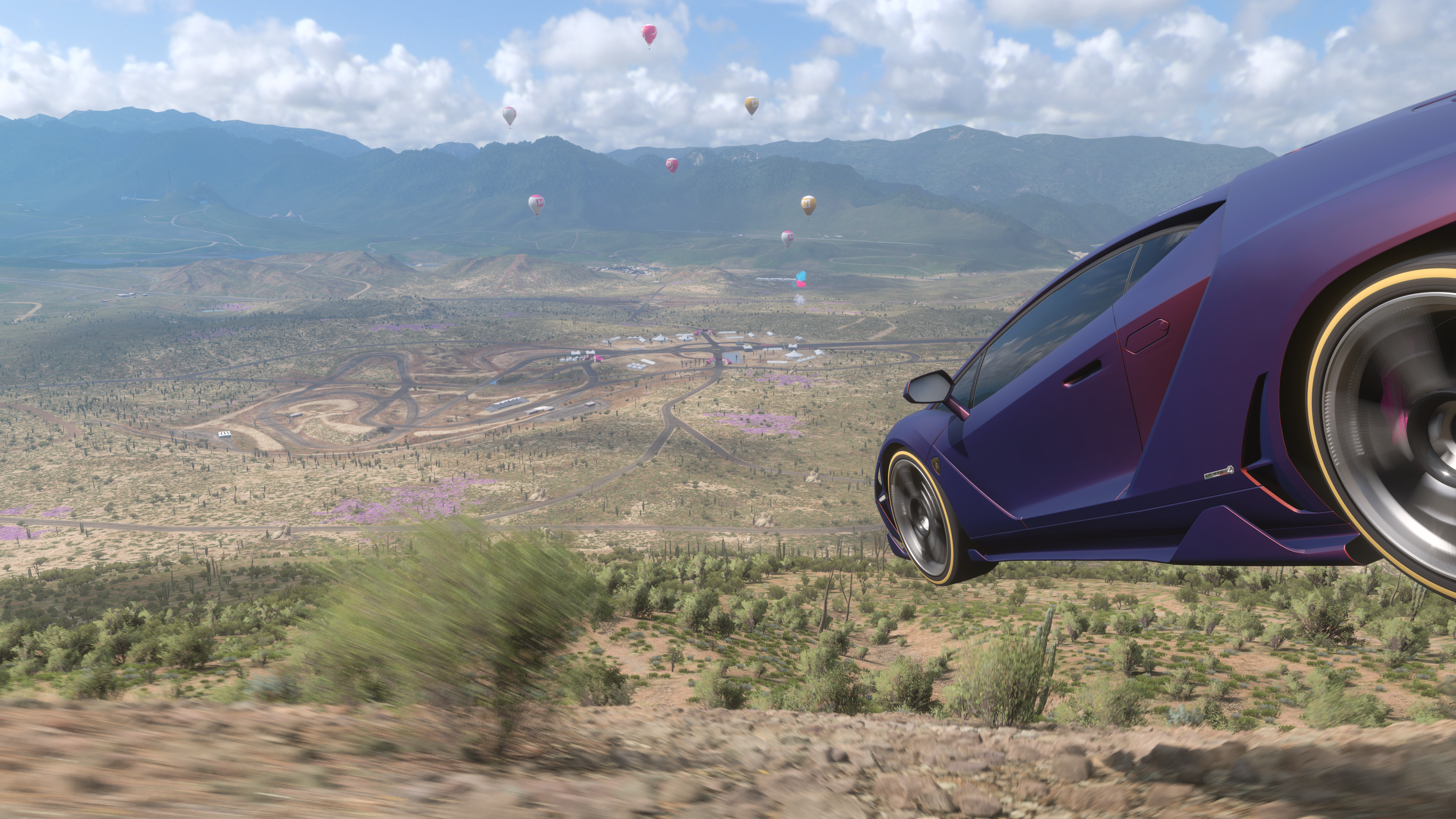 Forza Horizon 5 screenshot of a Lamborghini taking off as it hurtles downhill over Mexico.