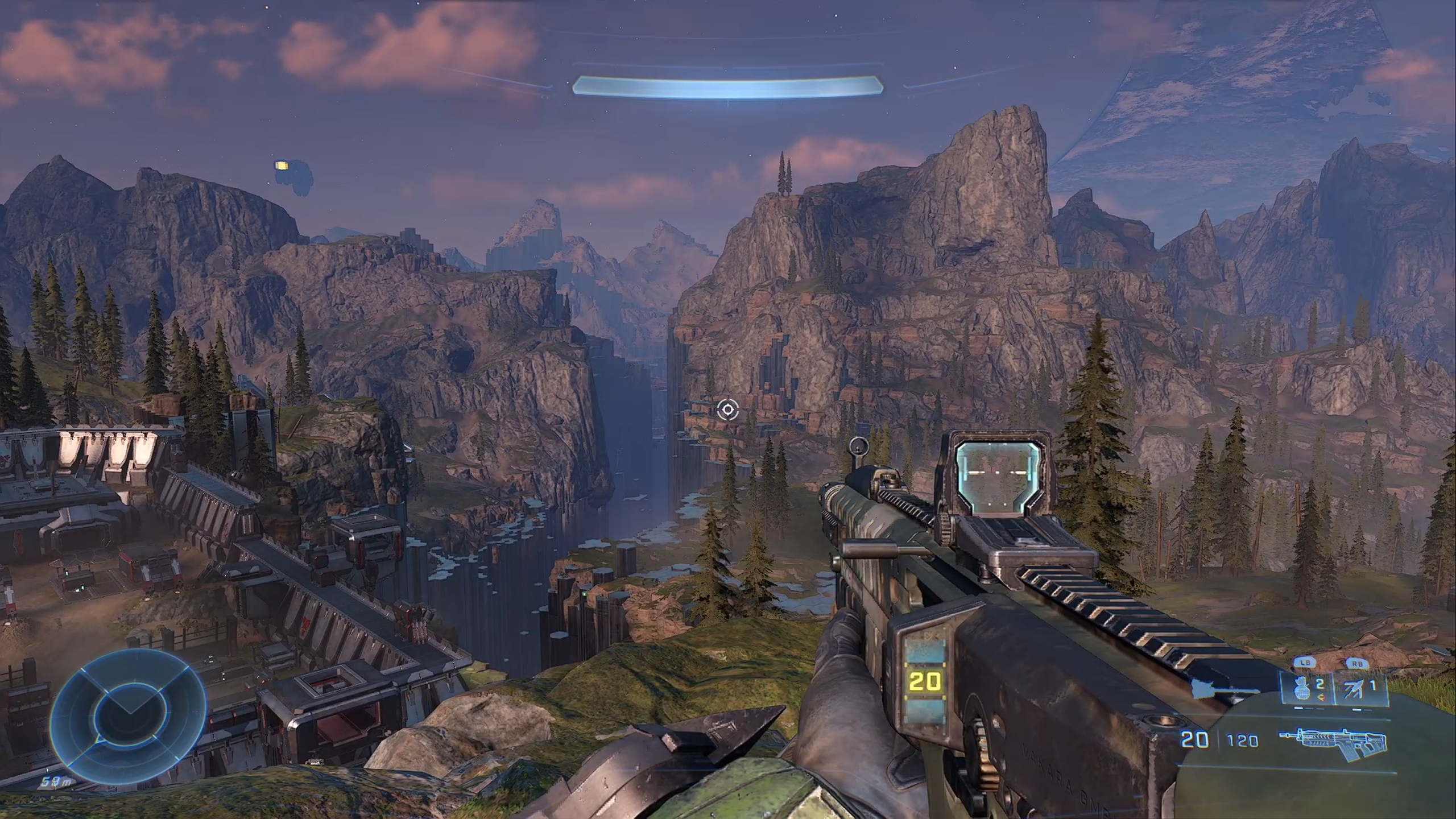 Screenshot of Halo Infinite from Master Chief's perspective looking out over an artificial valley with the ring in the distance.